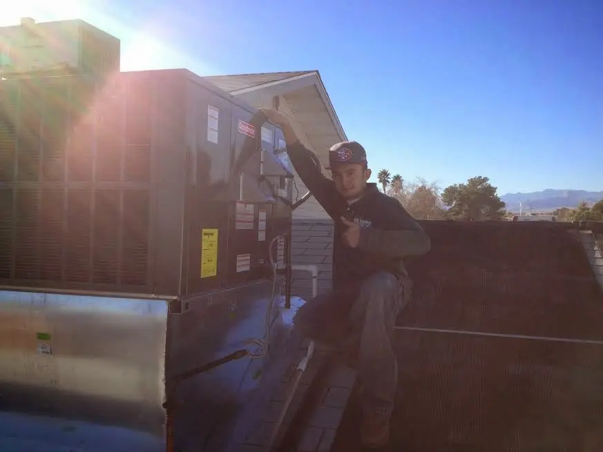 HVAC technician performing AC Tune-Up on a rooftop unit in Rock Hill