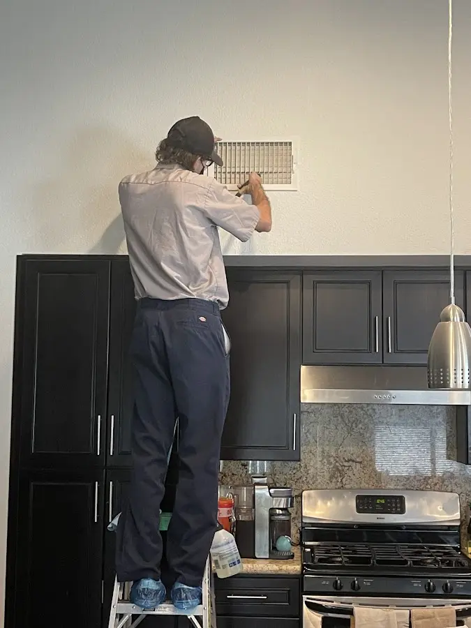 Technician inspecting an air vent during HVAC service in Rock Hill